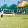 Due persone giocano a tennis su un campo all'aperto.