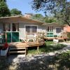 Bungalow in legno con verande in un giardino.