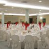 Sala banchetti con tavoli e sedie bianche.