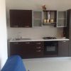 Una cucina moderna con mobili scuri, un forno e un lavandino.