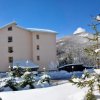 Edificio rosa in un paesaggio innevato.