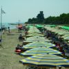 Spiaggia con ombrelloni a righe gialle e blu.